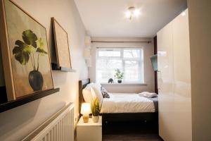 een kleine slaapkamer met een bed en een raam bij Dunstable Rd Modern Ensuites by Pioneer Living in Luton