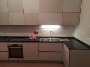 a kitchen with white cabinets and a sink at Delizioso appartamento al Pigneto in Rome