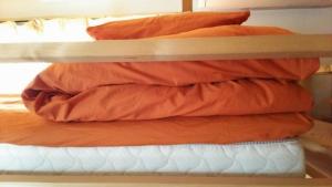 a stack of pillows on a bunk bed at Guesthouse MI CASA SU CASA in Zentsuji
