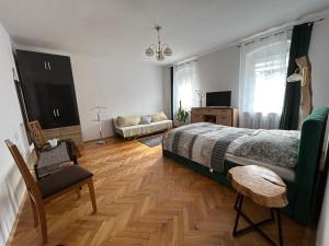 a bedroom with a bed and a chair and a couch at ARTHOME in Wrocław