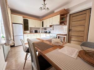 a kitchen with a wooden table and white cabinets at ARTHOME in Wrocław