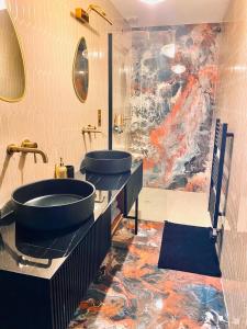 een badkamer met twee wastafels en een schilderij aan de muur bij Villa Caprice in Six-Fours-les-Plages