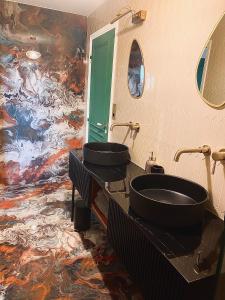 a bathroom with two sinks and a painting on the wall at Villa Caprice in Six-Fours-les-Plages