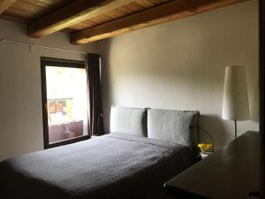 a bedroom with a large bed with a window at Baita Gran Bosco: appartamento per 6 persone in Monfol