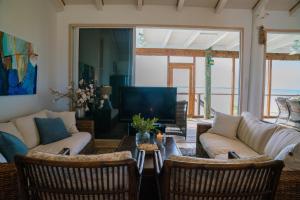 a living room with a couch and chairs and a tv at Villa Blue Hole in Mangrove Cay