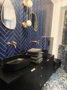 bagno con lavandino nero e piastrelle blu di Villa Caprice a Six-Fours-les-Plages
