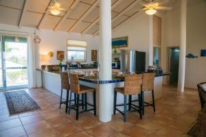 a kitchen with a large island with bar stools at Villa Blue Hole in Mangrove Cay