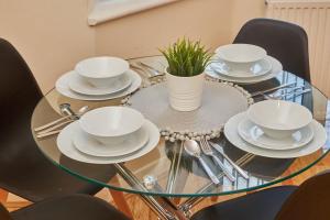 szklany stół z białymi naczyniami i rośliną w obiekcie Cosy Corner on Burton Road w mieście Derby