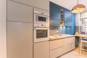 - une cuisine avec des appareils électroménagers blancs et des murs bleus dans l'établissement ARA Apart Hotel #3, à Braşov