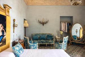 a bedroom with a bed and a chair and a mirror at Villa De Cillis Carafa in Torre del Greco