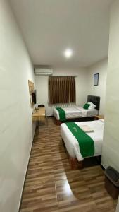 Cette chambre comprend deux lits et une télévision. dans l'établissement Bima guest house, à Ngadipuro