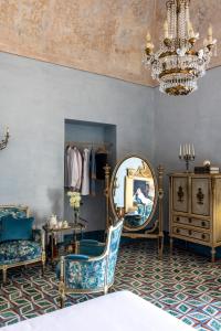 a room with chairs and a mirror and a chandelier at Villa De Cillis Carafa in Torre del Greco