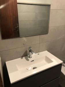 La salle de bains est pourvue d'un lavabo blanc et d'un miroir. dans l'établissement Beach Apartment 1 and Beach Apt 2 75 metres to the beach, à Santa Maria