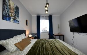 a bedroom with a bed and a flat screen tv at SuperApart Prymasa 1000-lecia 6a, Hidden Gem - Ideal for Relaxation & Escapes in Rzeszów