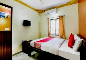 班加羅爾的住宿－Super Collection O 81138 Emara Galaxy Executive Rooms，一间卧室配有一张带红色枕头的床和一扇窗户