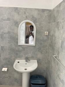 a man taking a picture of himself in a bathroom mirror at Auberge Andel Diabou SARR in Palmarin +38 photos