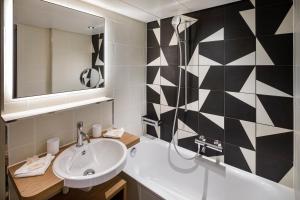 uma casa de banho com um lavatório e um espelho em Swiss Chocolate by Fassbind Zurich em Zurique