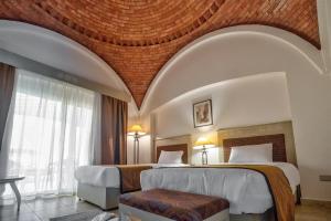 Amarina Queen Resort Marsa Alam في مرسى علم: غرفة فندقية بسريرين ونافذة كبيرة