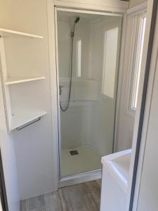 a shower with a glass door in a bathroom at Mobilhome camping 4étoiles Côte d'Azur in Cagnes-sur-Mer