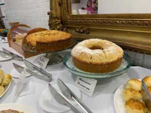 a table topped with cakes and other desserts on plates at Syros Hotel in Gama