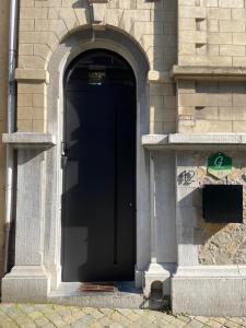a black door on the side of a building at La cave de Nana in Liège