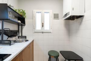 a small kitchen with a sink and two stools at Panzani 13 in Florence +15 photos