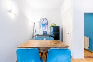 a dining room with a table and blue chairs at Panzani 13 in Florence