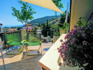 two chairs and an umbrella on a patio at Luna Rossa in Castel di Tusa