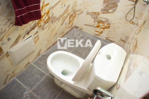 a bathroom with a white toilet and a sink at Studio Le Parisien in Pointe-Noire