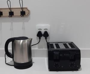 a coffee pot and a toaster on a kitchen counter at Blombos Self-Catering House in Franskraal