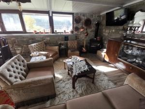 a living room with furniture and a stone wall at Kostaki's Stonehouse 2 in Ágnanta