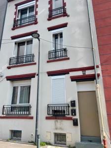 - un bâtiment blanc avec un balcon et un éclairage de rue dans l'établissement Pleyel cosy, à Saint-Denis