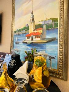 a picture of a painting of a lighthouse and a jug of juice at Aprilis Gold Hotel - Special Category in Istanbul