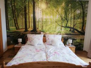 a bedroom with a forest mural on the wall at Ferienhaus Karin in Rieding
