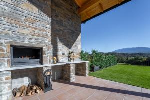 un patio al aire libre con chimenea en una pared de piedra en Casa rural de lujo en Alt Urgell, Pirineos. en Aravell