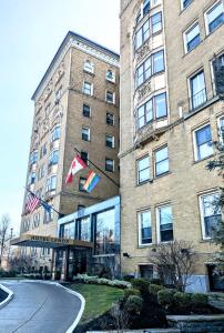 un gran edificio de ladrillo con dos banderas. en Lenox Hotel and Suites, en Buffalo
