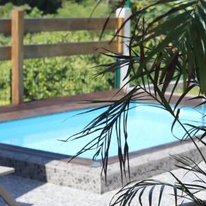 um banco de madeira ao lado de uma piscina em Palmier bungalow- piscine em Gros-Morne