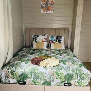 - un lit avec une couverture dans l'établissement Palmier bungalow- piscine, à Gros-Morne