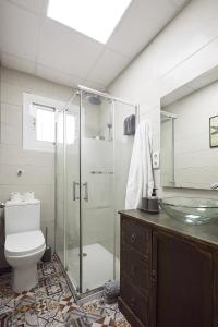 a bathroom with a glass shower and a toilet at Low Cost Apartments Center Elche in Elche