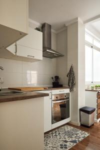 a kitchen with white cabinets and a stove at Low Cost Apartments Center Elche in Elche