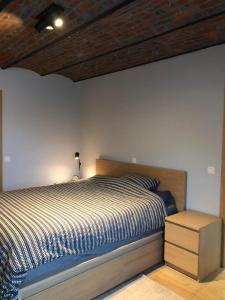 a bedroom with a bed and a wooden ceiling at Chez Raoul - Ancienne Grange in Pont-à-Celles