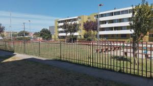 uma cerca de metal em frente a um edifício em Depto Gesoli em Hualpen