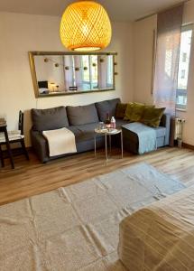 a living room with a couch and a table at Südstadtoase • Tübingen &freeParking in Tübingen