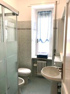 een badkamer met toilet, wastafel en raam bij Casa Marri in Camogli