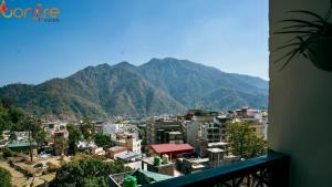 vistas a una ciudad con montañas en el fondo en Bonfire Hostels Rishikesh, en Rishīkesh