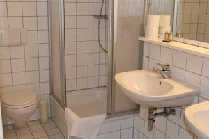 a bathroom with a sink and a toilet and a shower at Hotel Café Rhönperle in Bad Neustadt an der Saale