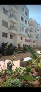a large apartment building with plants in front of it at Porte de mer Apartement in Essaouira