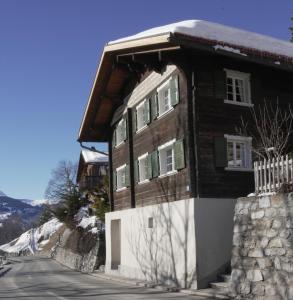 a wooden house on the side of a road at Historisches Walserhaus near Arosa in Peist