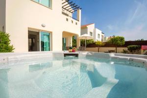 a swimming pool in front of a house at Villa Ivy in Protaras