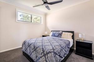 1 dormitorio con 1 cama y ventilador de techo en Sydney Blue Mountain Retreat, en Kingswood